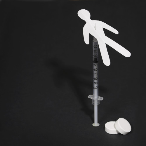 Drug Addiction Concept. Paper man with syringe and pills